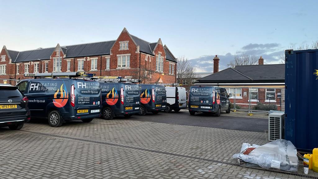 a group of vans and cars parked in a car park